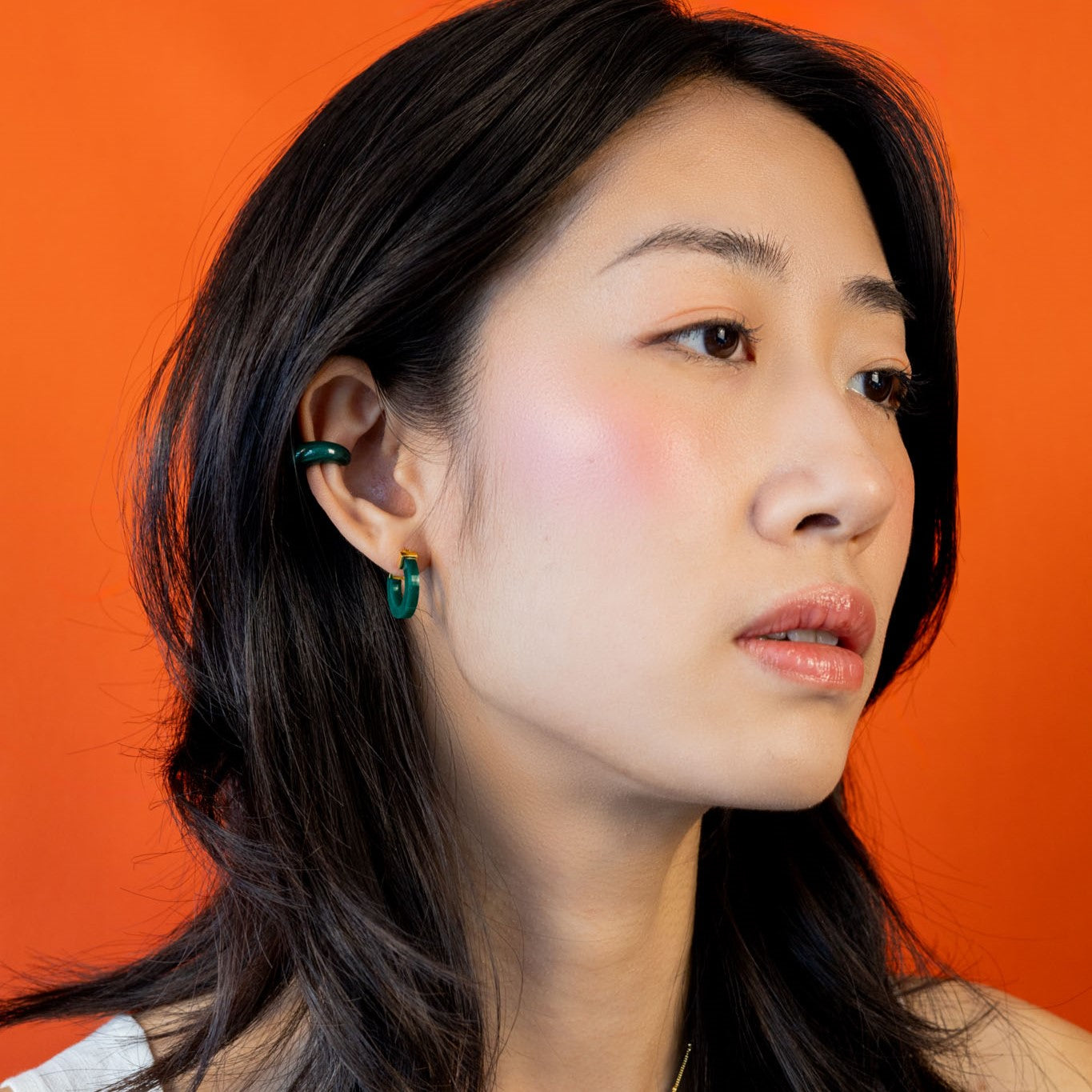Chinese woman wearing modern Chinese jewelry: jade ear cuff and jade earrings/hoops