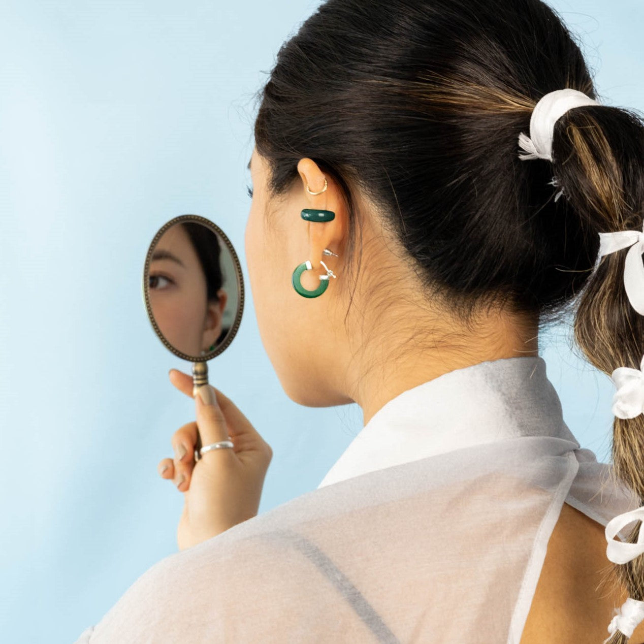 Modern Chinese jewelry on model featuring jelly "jade" ear cuffs and jelly "jade" hoop earrings.