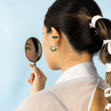Modern Chinese jewelry on model featuring jelly "jade" ear cuffs and jelly "jade" hoop earrings.