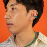 A man wearing the Heaven and Earth necklace; a modern Chinese jewelry piece that can be worn as a necklace or taken apart to form two bracelets.