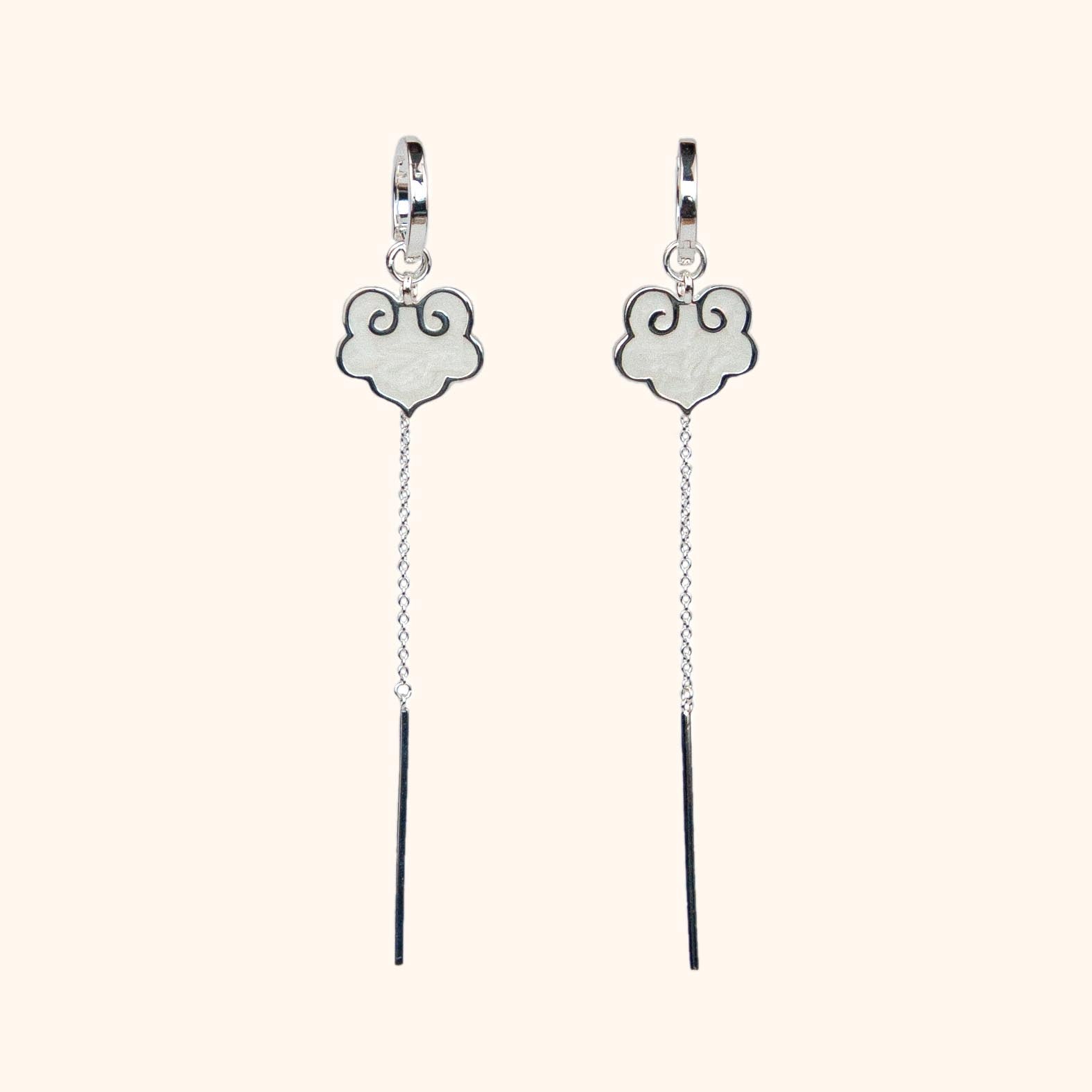 Ruyi earrings with ruyi shaped charms outlined in silver and filled with pearlescent white enamel.