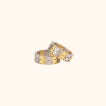 Two two-tone, modern Chinese-inspired rings made of the Chinese happiness character, set on a white background.