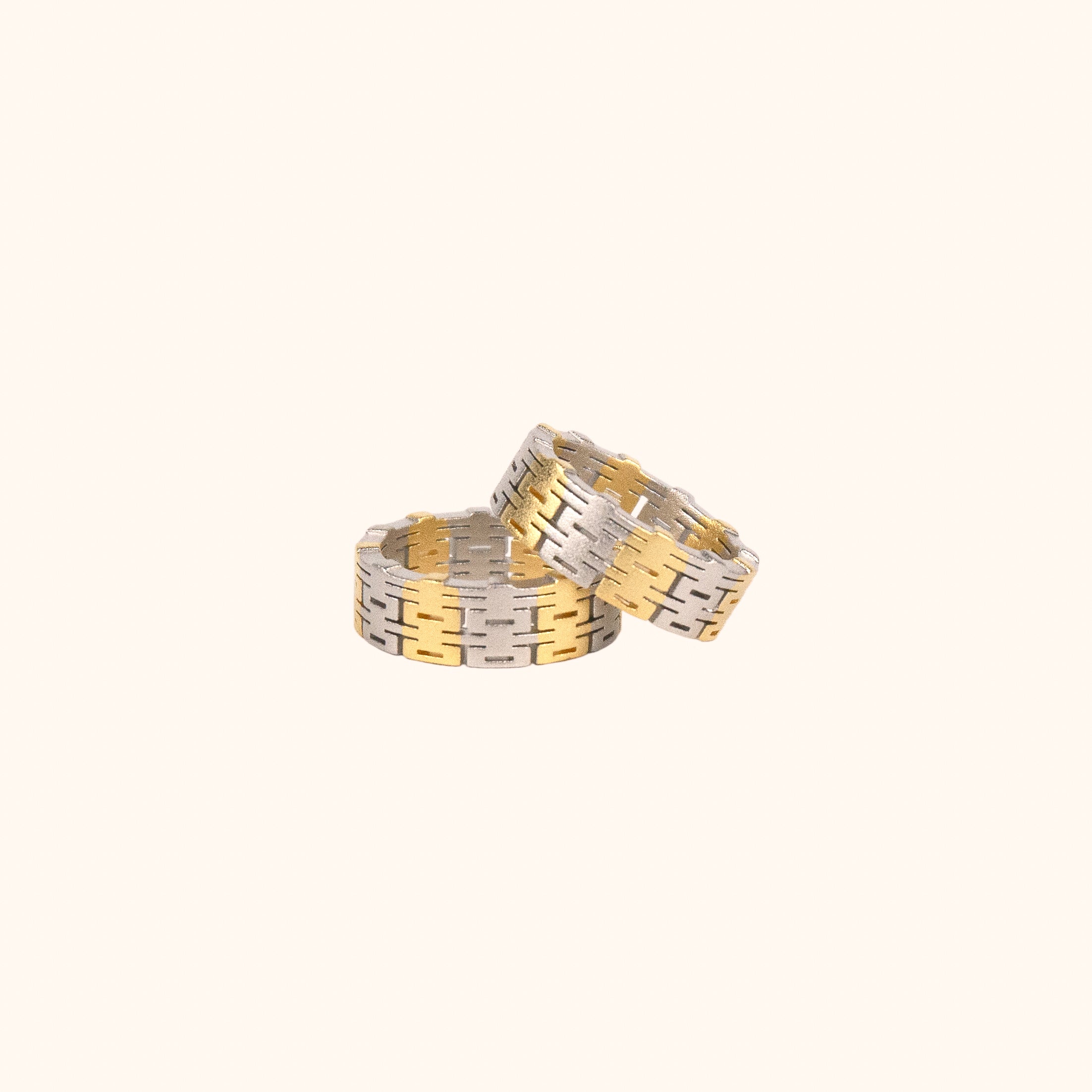 Two two-tone, modern Chinese-inspired rings made of the Chinese happiness character, set on a white background.