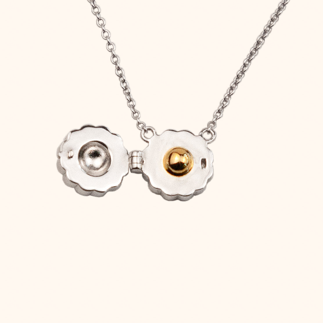 Mini Mooncake Locket in sterling silver. The locket opens to reveal the salted egg yolk in 18k gold plating, contrasting with the silver locket.