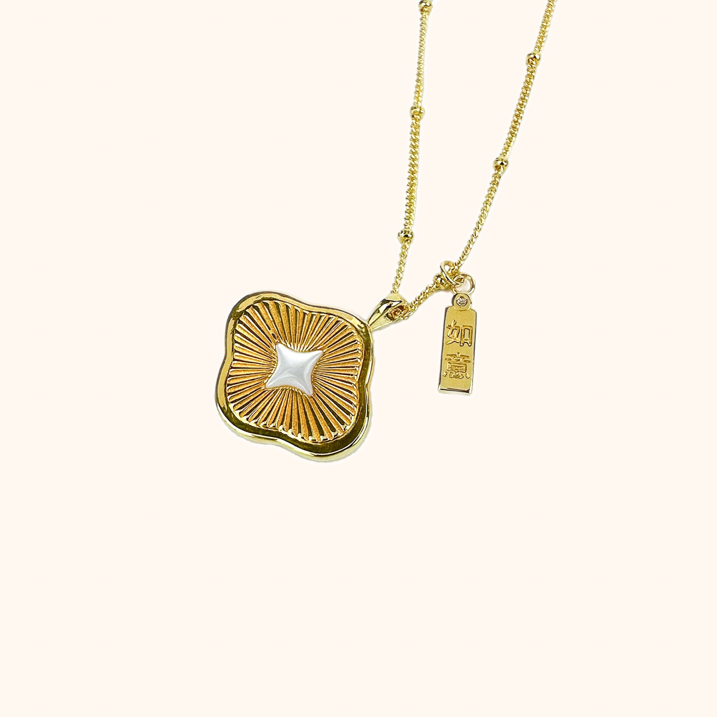 Modern Chinese necklace with a ruyi silhouette, sunray texture, mother of pearl star, and ruyi tag with cubic zirconia for good luck.